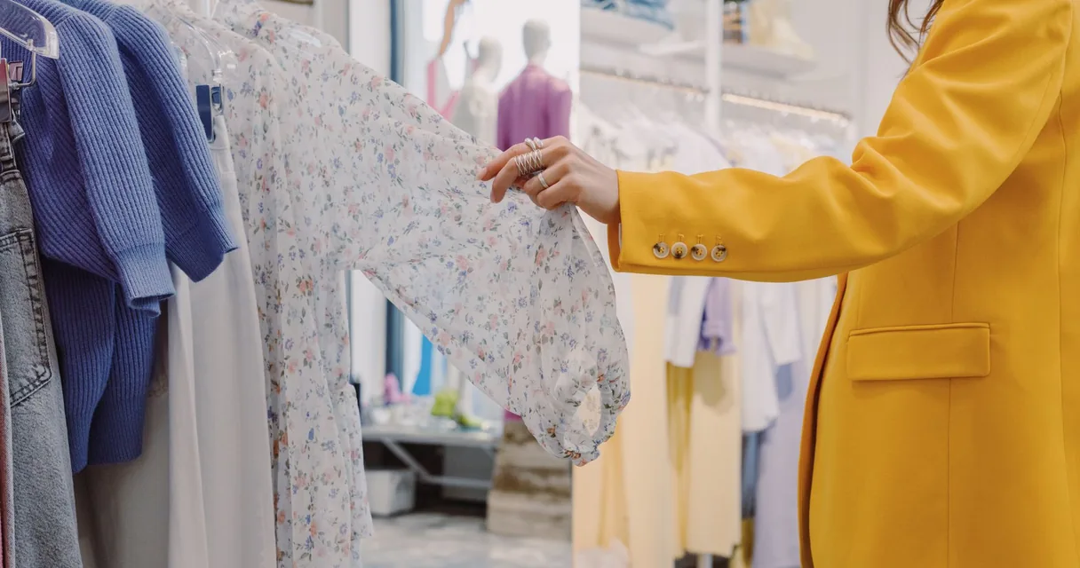 Mulher escolhendo roupas em uma arara
